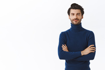 Confident good-looking male entrepreneur in blue high neck sweater, cross arms over chest, smirk...