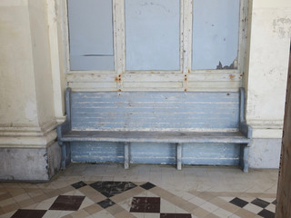 old blue wooden bench in a corridor of a gallery