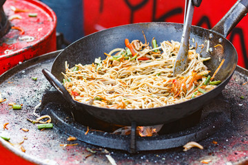 chef cooks Chinese noodle wok at street food festival