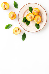 Fototapeta na wymiar Healthy food. Ripe sliced peaches on plate on white table top-down copy space