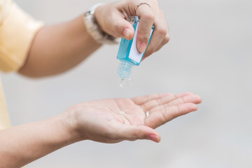 Woman hands using wash hand sanitizer gel dispenser, against Novel coronavirus or Corona Virus Disease (Covid-19) at public train station. Antiseptic, Hygiene and Healthcare concept