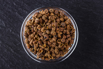 Sichuan pepper on a dark stone background