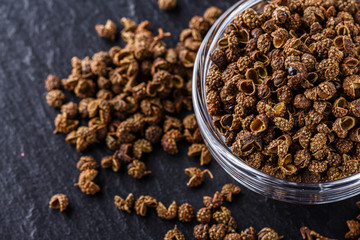 Sichuan pepper on a dark stone background