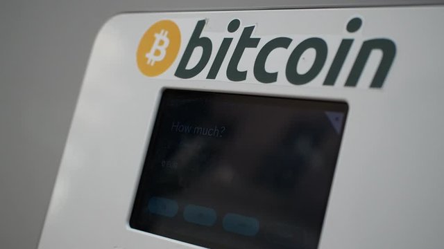 Woman selling bitcoin on cryptocurrency ATM machine in HD VIDEO. Blockchain technology in real life concept. Close-up.