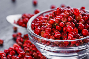 pink peppercorns on a dark stone background