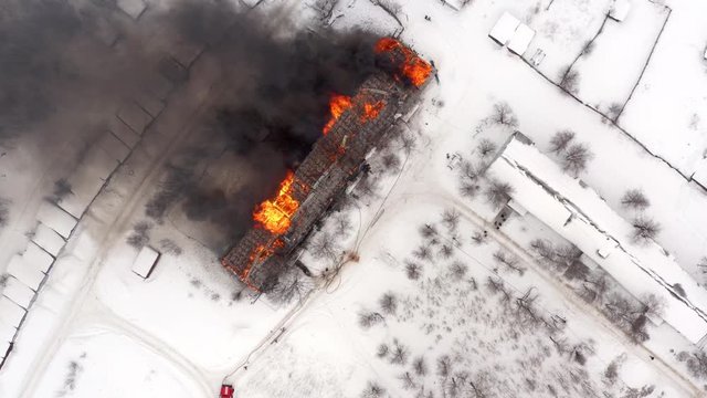 Aerial view the burning roof of the building in winter.