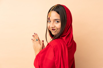 Young Indian woman isolated on beige background scheming something