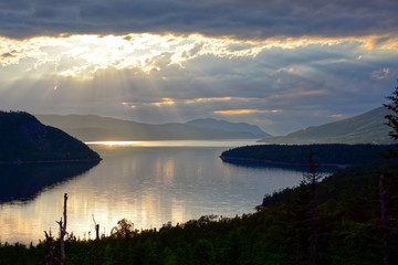 Beautiful image of sun rays in a dramatic summer morningsky over Bras East Arm in Gros Morne...