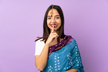 Young Indian woman isolated on purple background showing a sign of silence gesture putting finger in mouth