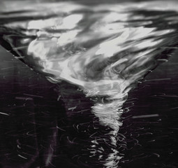 swirling spinning water in a glass with bubbles isolated on a black background