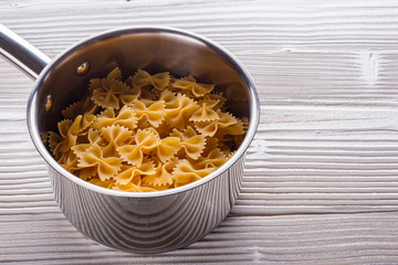 traditional italian pasta in a metal pan on a wooden background