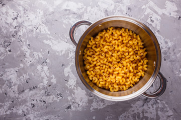 Traditional Italian pasta in a metal pan on a stone background