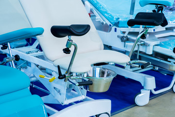 Blue gynecological chair in medical office in clinic. Modern interior in the gynecologist's office.