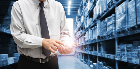 Businessman is standing at office of warehouse, he is planning management smart logistic concept