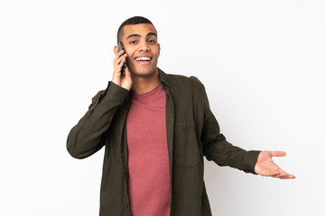 Young African American man over isolated white background keeping a conversation with the mobile phone with someone