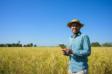 A farmer holding a tablet To check the financial results of agriculture