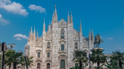 The Duomo cathedral timelapse with palms and monument. Front view with people walking on square