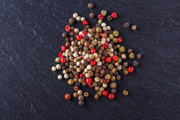 mix of peppercorns on a dark stone background
