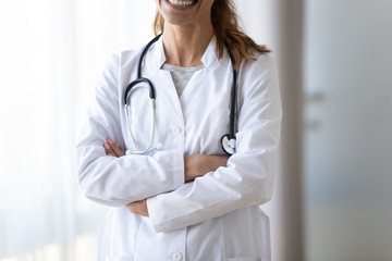 Cropped smiling female doctor in white uniform with stethoscope
