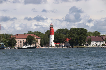 Red and white lighthouse in Baltiysk, Kaliningrad region. Russia Bay in the foreground