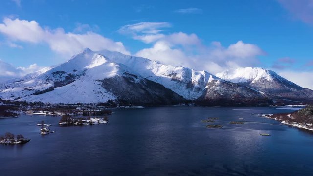 aerial drone footage of winter in glencoe and and loch Leven in the argyll region of the highlands of scotland showing clear bright white snow on the mountains of glencoe and the surrounding region