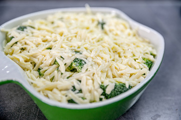 Fresh yummy food - broccoli with cheese on top of it in baking dish.