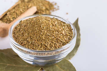 ground dried bay leaf on white acrylic background