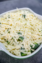 Fresh yummy food - broccoli with cheese on top of it in baking dish.