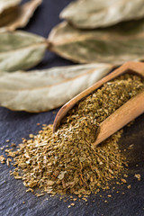ground dried bay leaf on a dark stone background