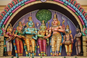 Fototapeta na wymiar bright figures of the gods on the gopurama of a hindu temple in sri lanka