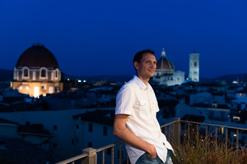 Firenze, Italy city with famous architecture church duomo in summer evening night cityscape of dome and young man on rooftop