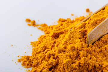 natural turmeric powder on white acrylic background
