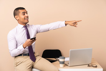 Young business man in a office pointing finger to the side