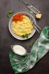 Mashed potatoes with parmesan and carrots on a dark background. Vegan or vegetarian lunch and dinner. Top view, flat lay