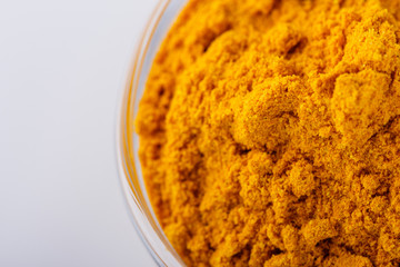 natural turmeric powder on white acrylic background