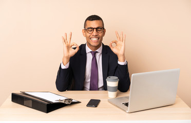 Young business man in his office with a laptop and other documents in zen pose