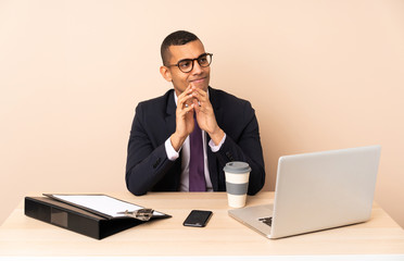 Young business man in his office with a laptop and other documents scheming something