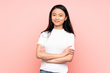 Fototapeta premium Teenager Chinese woman isolated on pink background keeping the arms crossed in frontal position