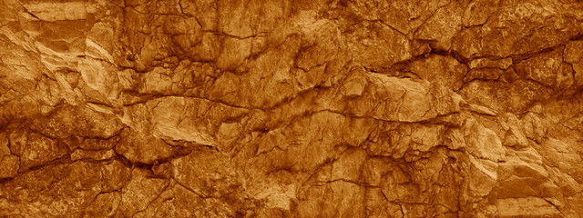 Brown orange rock background. Wide banner. Toned cracked mountains surface texture. Close-up. Stone...