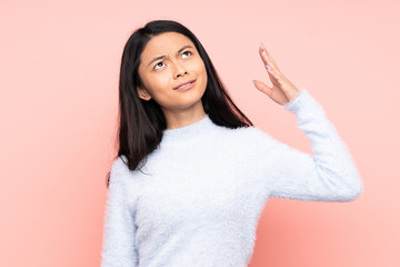 Teenager Chinese woman isolated on pink background with tired and sick expression