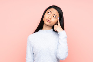 Teenager Chinese woman isolated on pink background with problems making suicide gesture