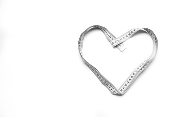 The figure is heart of a centimeter tape. Isolate measuring tape on a white background.