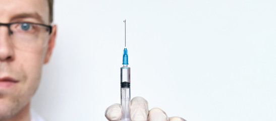 Male person in white glove hold vaccine bottle with syringe. Injection pharmacy concept. Medical...