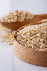raw brown rice on white acrylic background