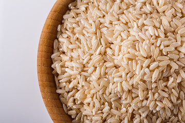 raw brown rice on white acrylic background