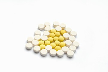 The concept of pills for treatment. Multi-colored white, yellow tablets on a white isolate background . Copy space. Place for text.