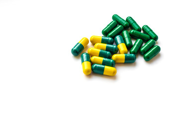 Medicine concept. Green and yellow pills on a white background. Medicines for diseases, medical care. Place for text. Copy space. Isolated background.