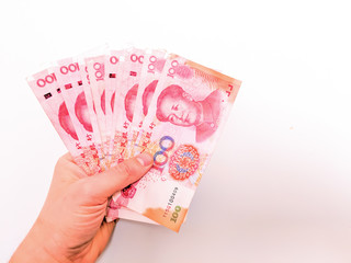 Hand holding one hundred Yuan notes against white background