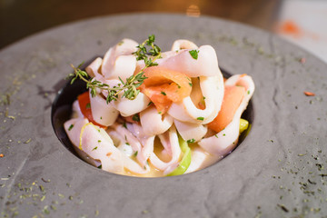 Plate with squid in white wine. Tasty food. Tasty seafood.