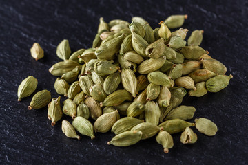 fragrant green cardamom on a dark stone background
